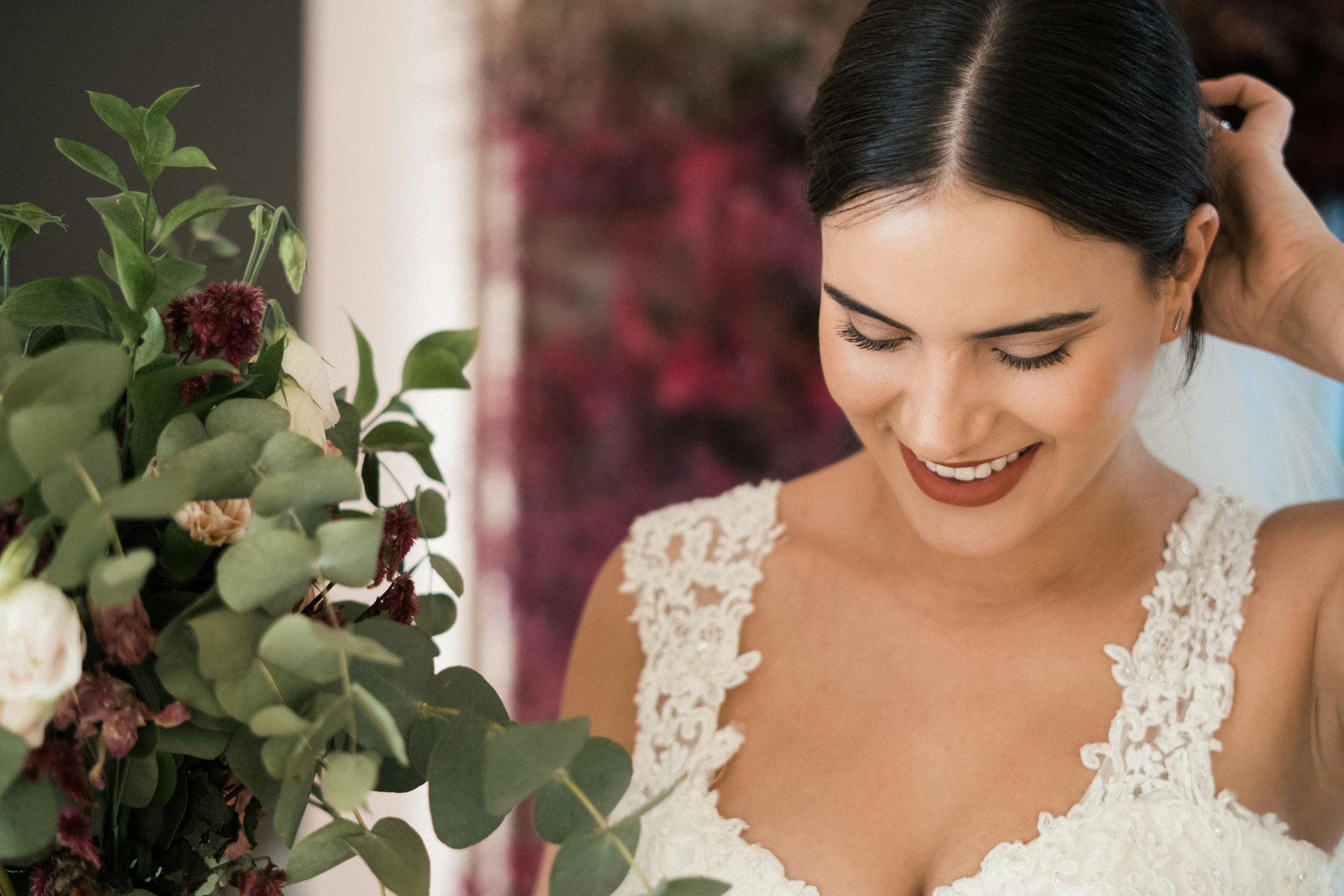 Close-up of a smiling bride holding a lush bouquet, capturing her joy.